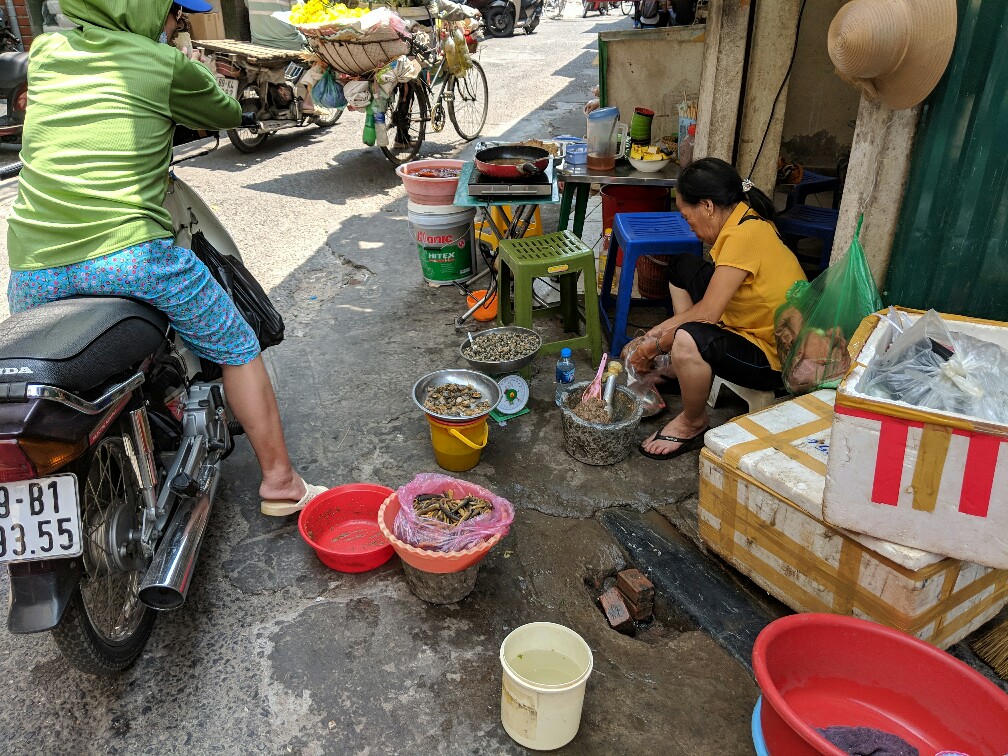 Femme faisant la cuisine dans une rue d'Hanoi