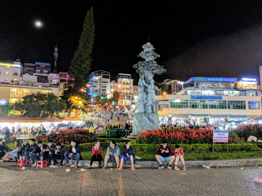Personnes assises sur la place principale du Marché de nuit de Da Lat