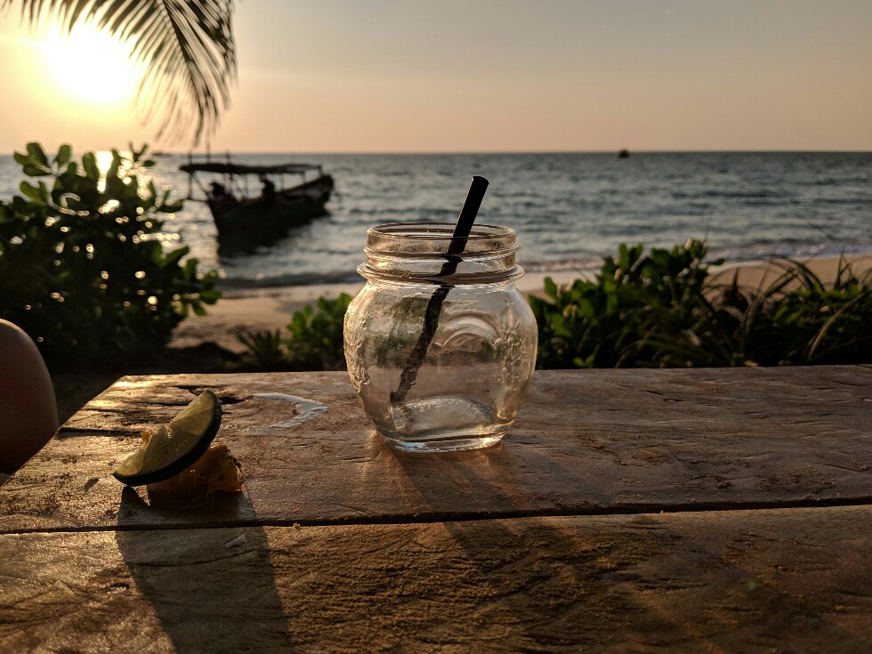 Verre de cocktail vide devant coucher de soleil à Sunset Beach sur Koh Rong Sanloem, Cambodge