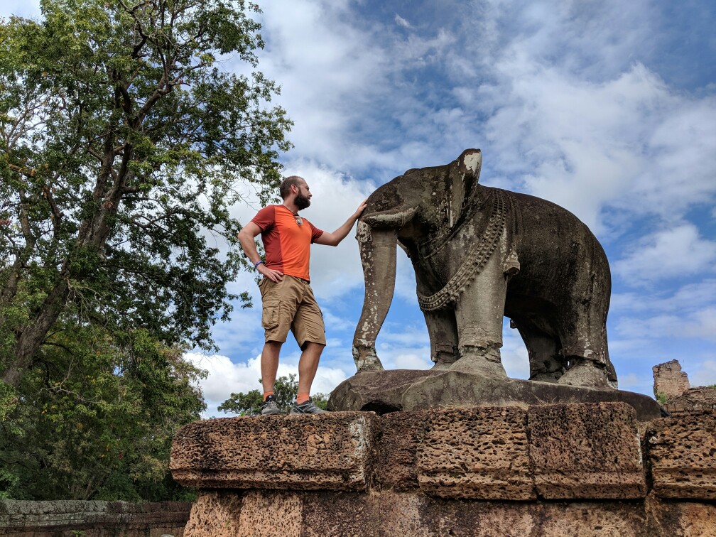 Sylvain carresse la statue dun éléphant au temple de East Mebon, Cambodge