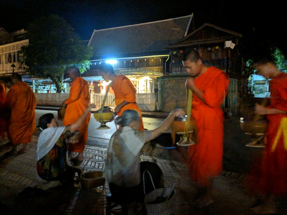 Aumonier donnant à un moine à Luang Prabang, Laos