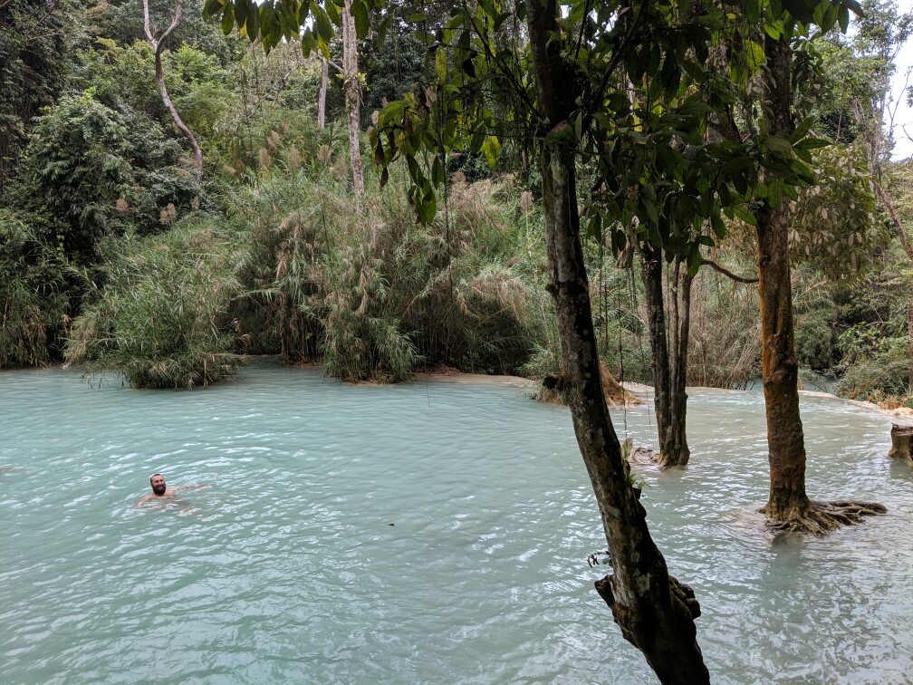 Sylvain se baigne dans l'eau turquoise des chutes de Kuang Si, Laos