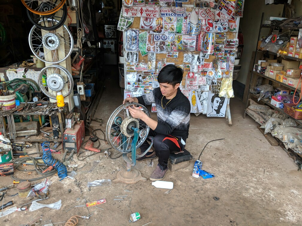 Le mécanicien changent les rayons de la roue près de Luang Namtha au Laos
