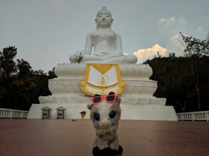 Biquette devant le Bouddha blanc de Pai, Thailande