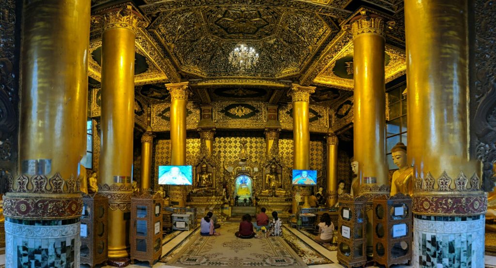 Salle de prière avec des écrans afficant Bouddha sur les côtés