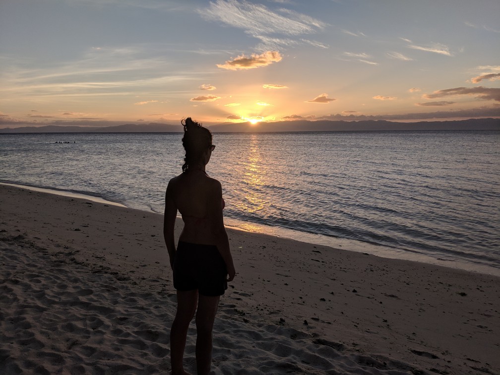 Salomé devant le coucher de soleil sur la mer à Lambug Beach