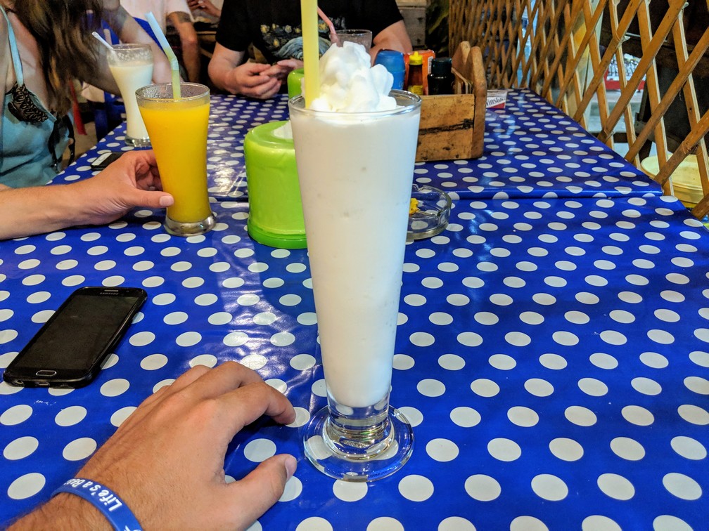 Un coconut shake dans un grand verre posé sur la table du restaurant