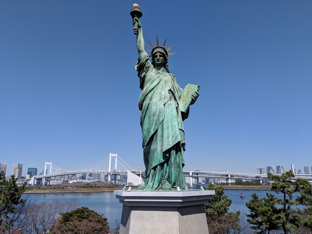 La statue de la liberté d'Odaiba avec le Rainbow Bridge en arrière-plan