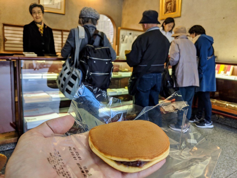 Un dorayaki est posé sur une main dans la boutique où il a été acheté