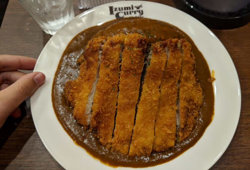 Un curry au porc dans une assiette pleine de sauce curry