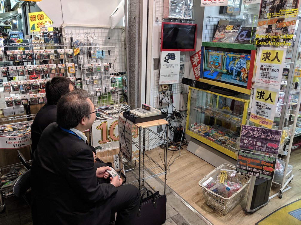 Deux salary men d'âge mûr s'affrontent devant une boutique de retro gaming