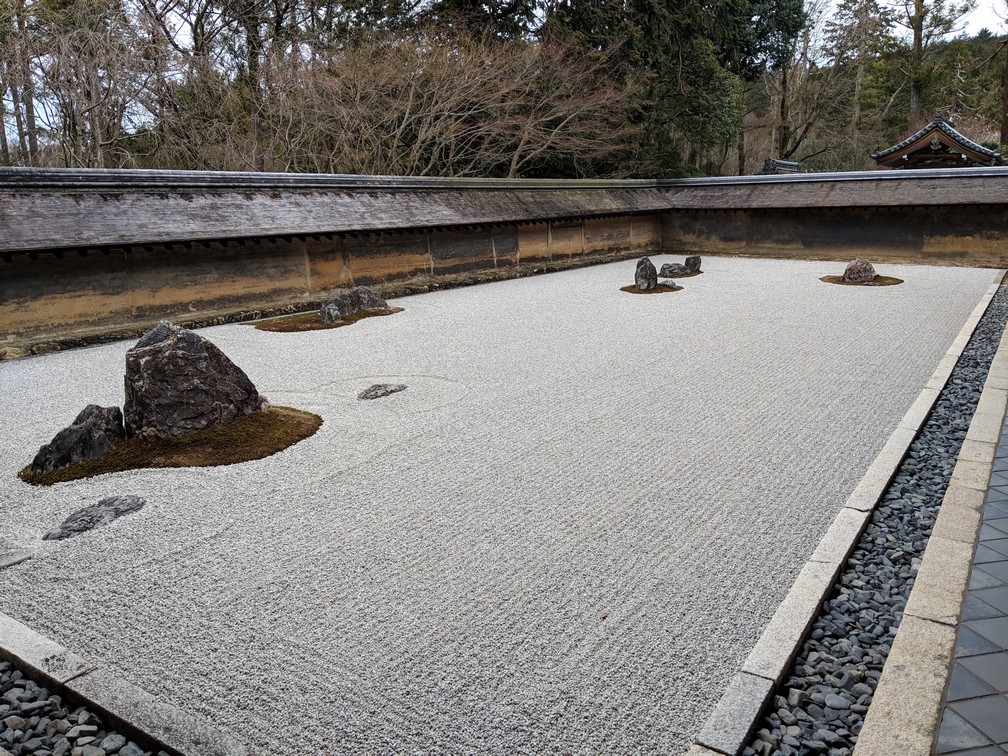 Un grand jardin zen avec des graviers parfaitement ratissés