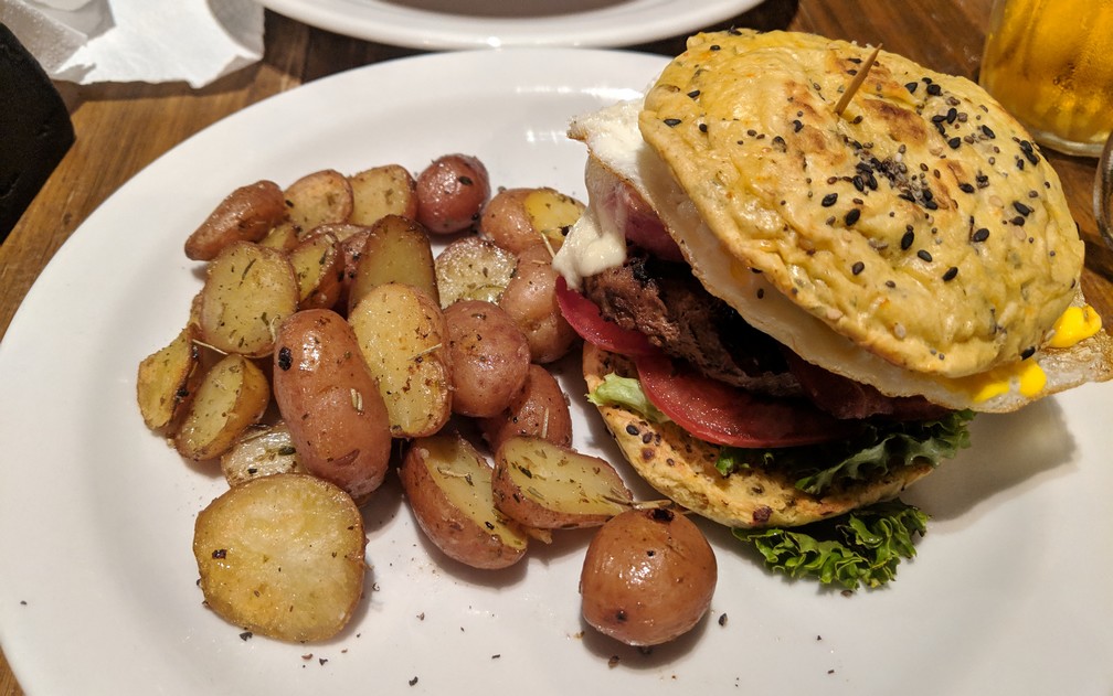 Un gros burger avec des petites patates en robe des champs