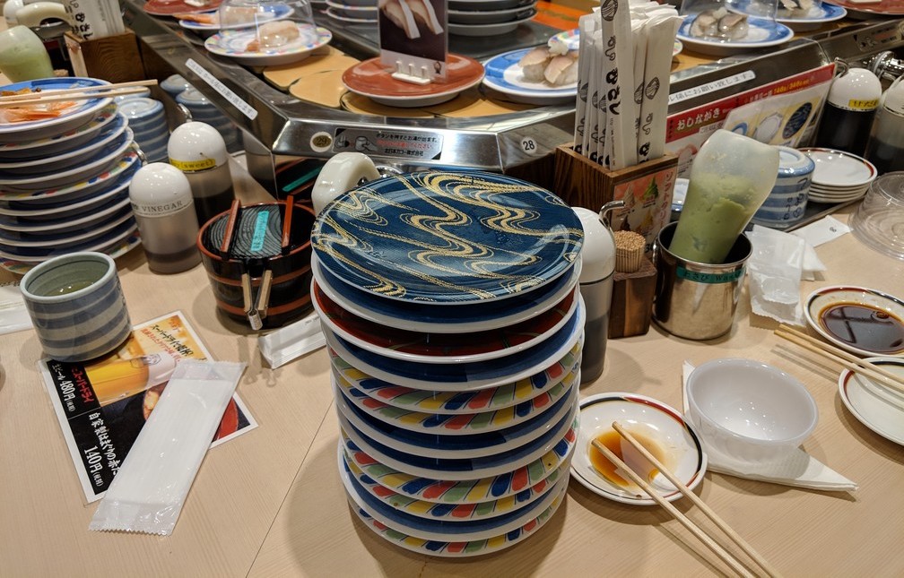 Plein de petites assiettes à sushi sont empilées, vides