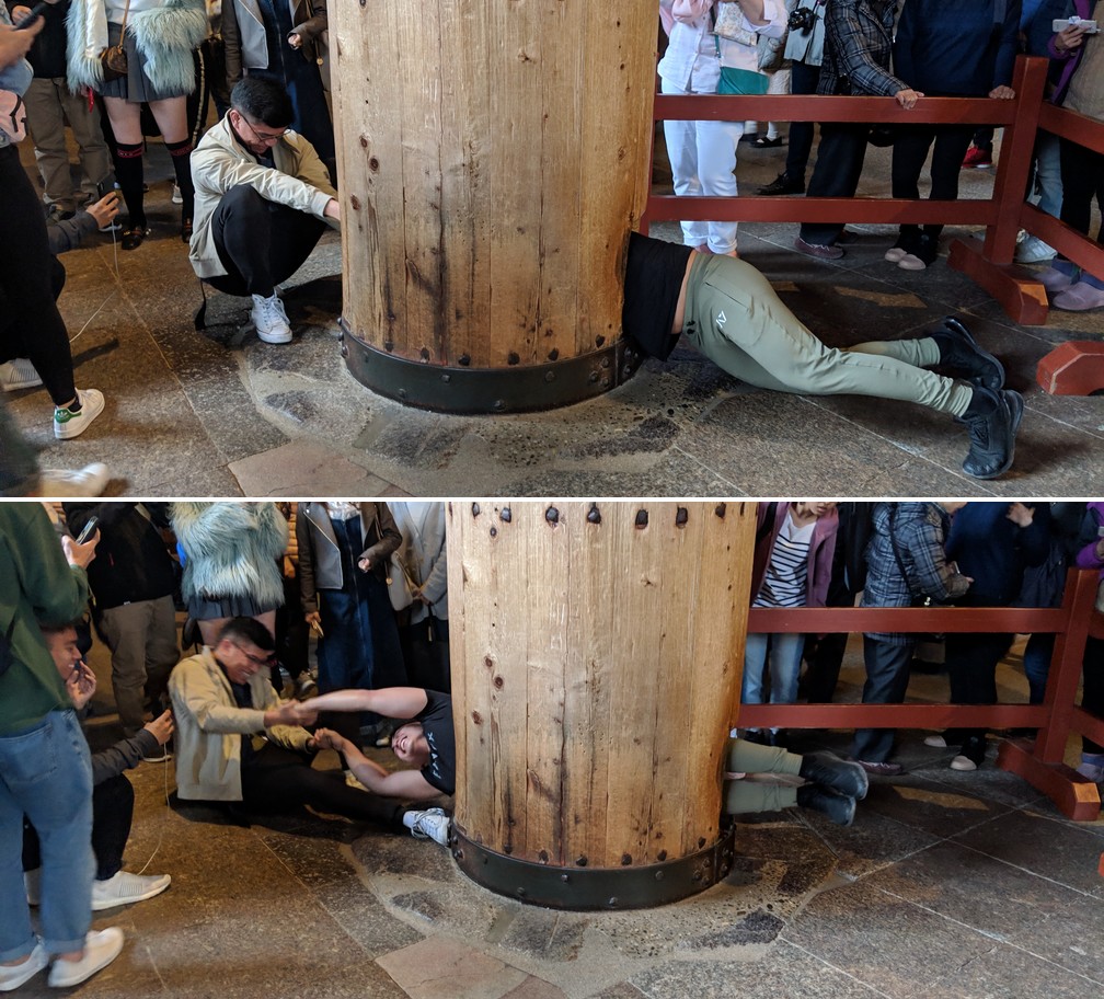 Un homme tente de traverser le pilier de bois percé au temple Todai-Ji de Nara