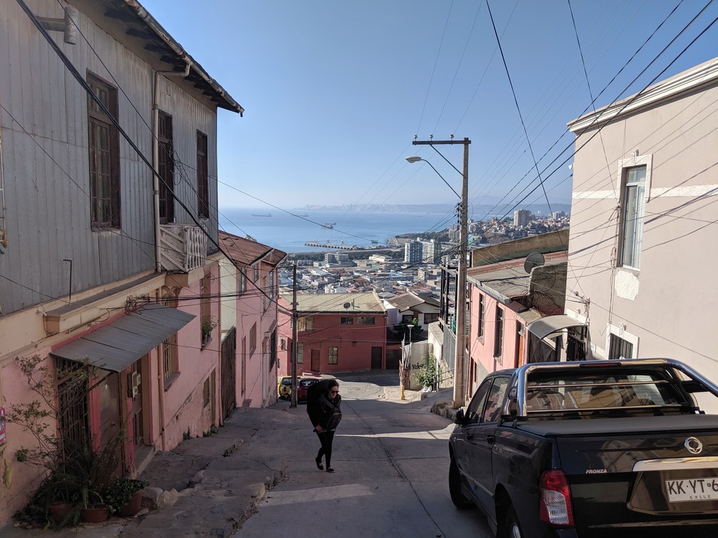 Salomé avec son gros sac à dos monte une rue dans Valparaiso