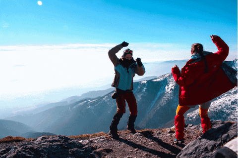 Gif animé de deux personnes qui dansent au sommet d'une montagne