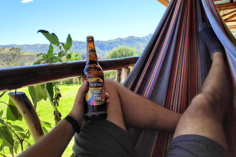 Sylvain déguste une bière dans un hamac avec vue sur les montagnes à Isinlivi
