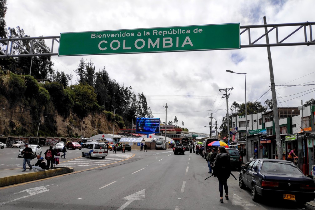 Salomé marche sous le panneau de frontière Colombien