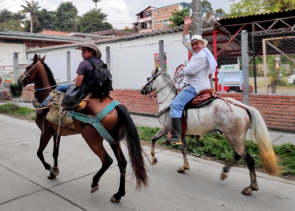 Deux hommes à cheval saluant les passants dans la rue à Salento