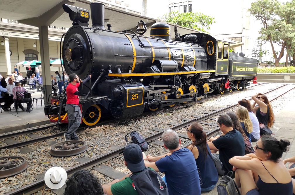 Un guide devant une locomotive ancienne à Medellin