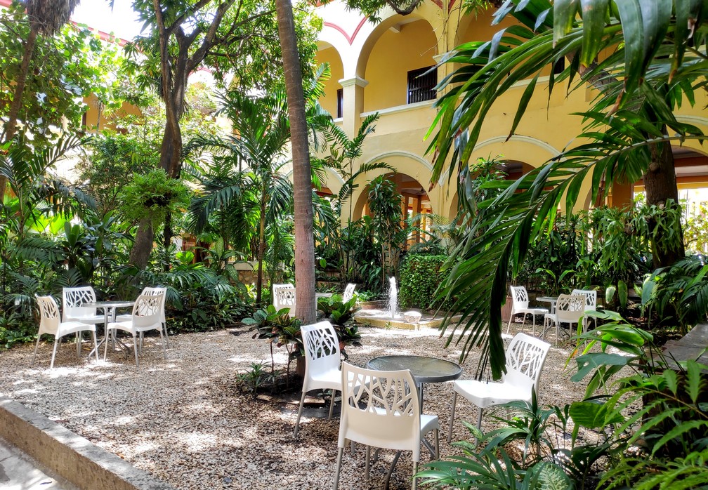 Patio typiquement colombien avec de la végétation et quelques tables et chaises