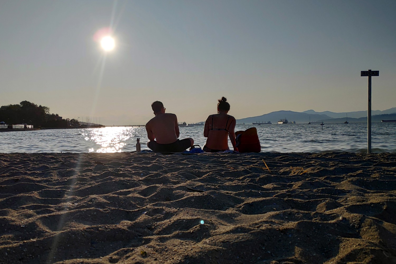 Couple assis plage Kitsilano Vancouver soleil couchant